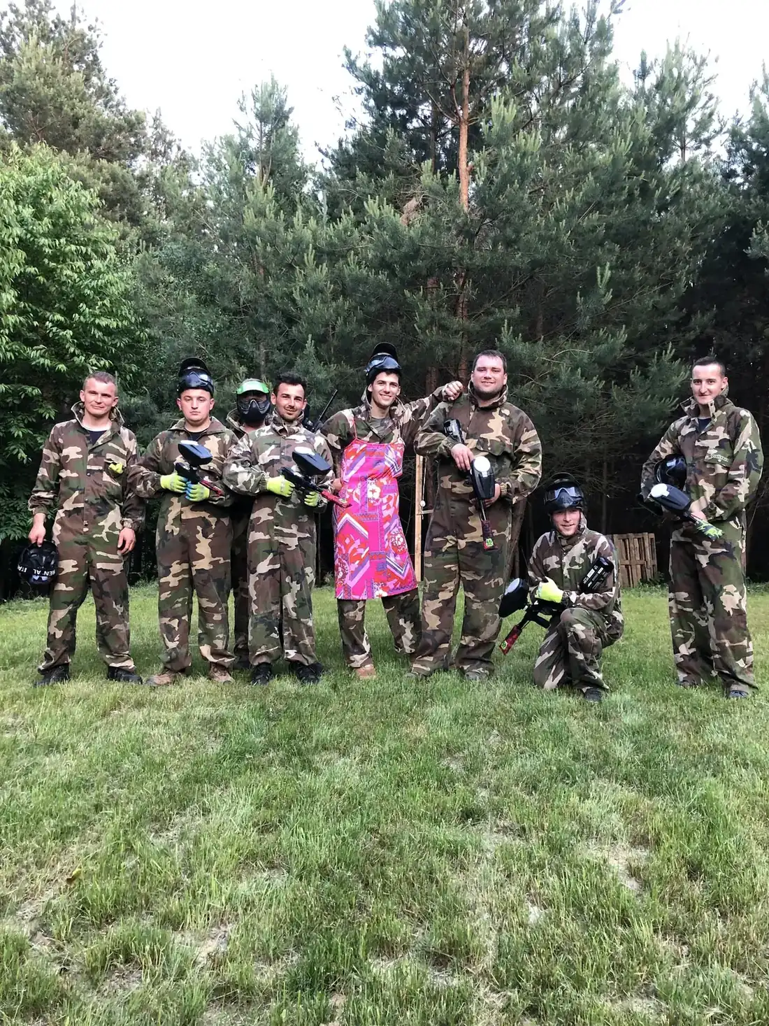 Grupa uczestniczek w kombinezonach na polu paintballowym Arpi